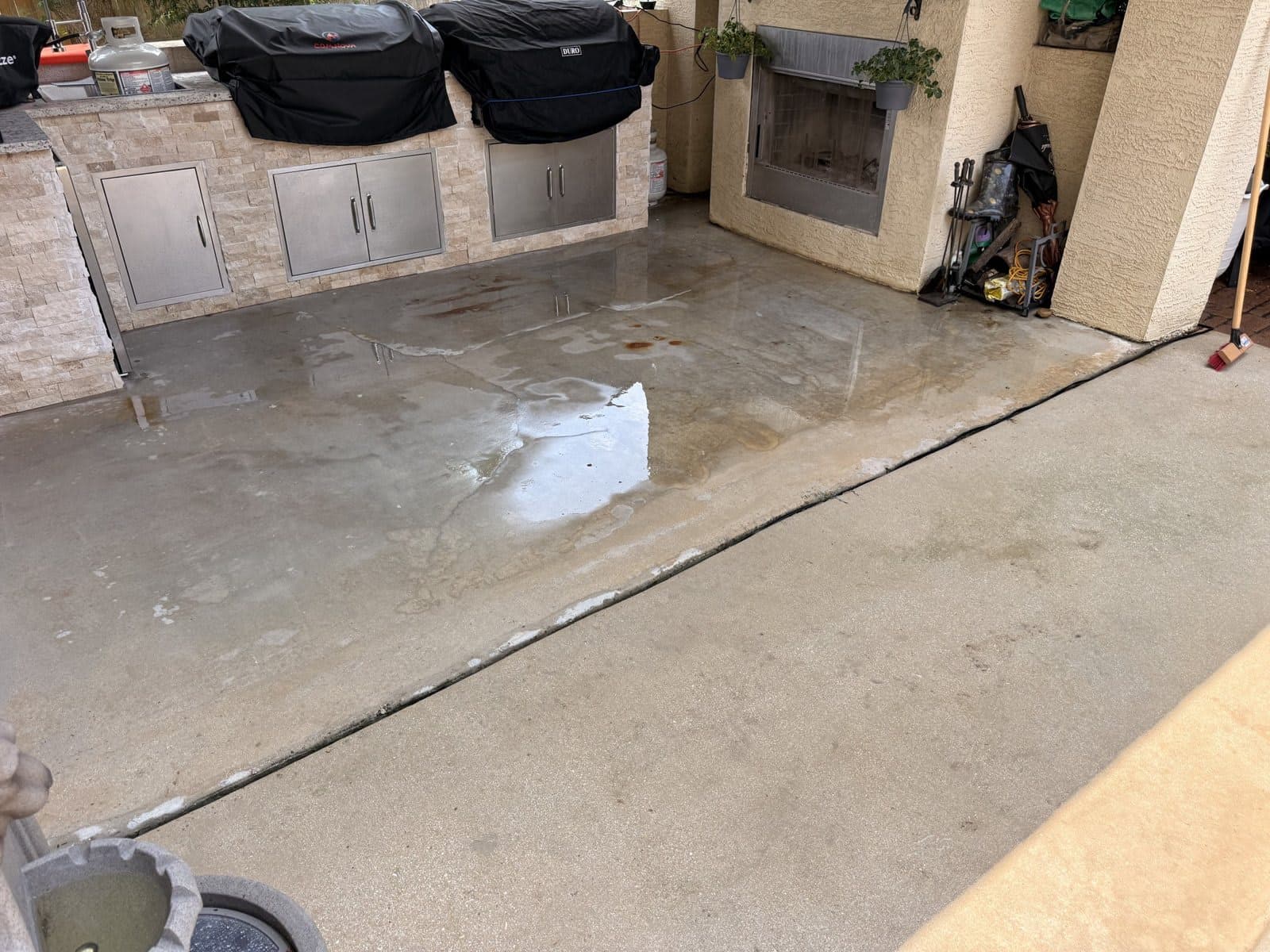 The same outdoor kitchen patio after pressure washing, clean wet concrete